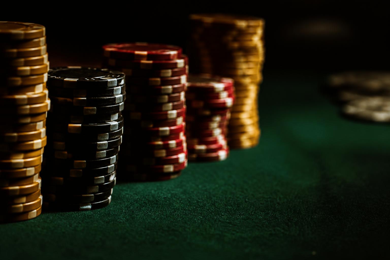 Fichas de poker empilhadas sobre feltro verde
